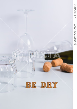 Dry January concept, empty glasses, bottles and corks on a gray background vertical view Dry January concept, empty glasses, bottles and corks on a gray background vertical view 121205833