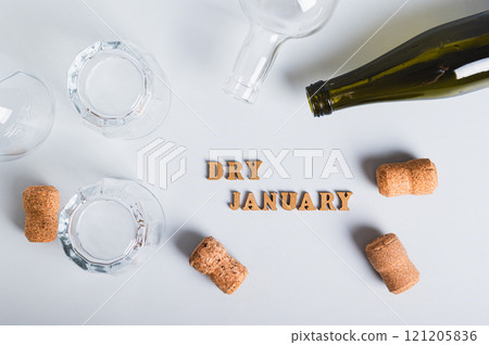 Dry January concept, empty glasses, bottles and corks on a gray background top view 121205836