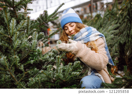 Happy woman buying a New Year tree for Christmas. Holiday concept, shopping. 121205858
