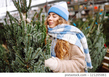 Happy woman buying a New Year tree for Christmas. Holiday concept, shopping. Happy woman buying a New Year tree for Christmas. Holiday concept, shopping. 121205861