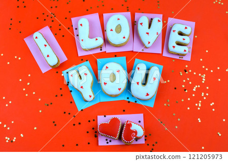 Homemade cookies in the form of a heart or I love you words on Valentine's Day on red background top view 121205973