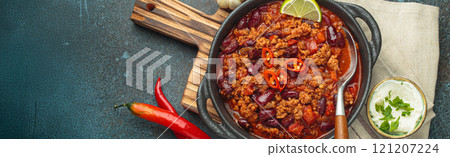 Mexican Chili con carne with minced meat, red beans, tomatoes, lime, and spices in a cast iron pot, space for text Mexican Chili con carne with minced meat, red beans, tomatoes, lime, and spices in a cast iron pot, space for text 121207224