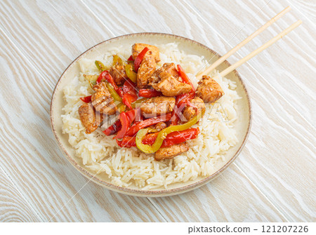 Chicken stir fry with peppers and rice on a plate with chopsticks top view Chicken stir fry with peppers and rice on a plate with chopsticks top view 121207226