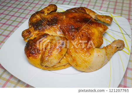 Whole roasted chicken on white plate with plaid tablecloth background Whole roasted chicken on white plate with plaid tablecloth background 121207765