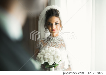Portrait of stunning bride with long hair posing with great bouquet 121207872