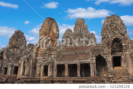 Ancient temple Bayon Angkor complex with stone faces of Buddha in Siem Reap on blue sky cloudy background, Cambodia 121208126