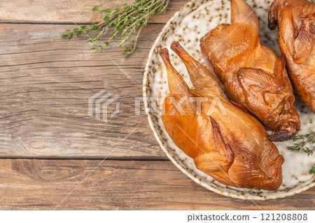meat smoked quail with herbs on a wooden background. top view. copy space 121208808