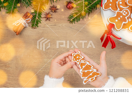 Children's Hands holding ginger Christmas tree cookie. Atmospheric Christmas holidays, family time, Top view. Copy space 121208831