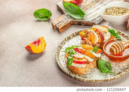 bread sandwiches with sweet peach slices, cream cheese and basil leaves. copy space for text. top view 121208847