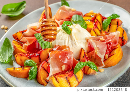 Salad with grilled peaches, mozzarella, prosciutto ham, basil, for wine. top view 121208848
