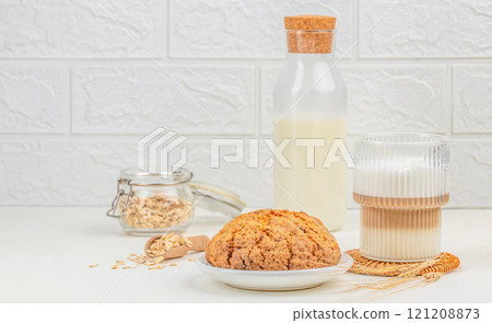 Healthy gluten free oatmeal cookies on white background, glass of latte on a light background, copy space Healthy gluten free oatmeal cookies on white background, glass of latte on a light background, copy space 121208873