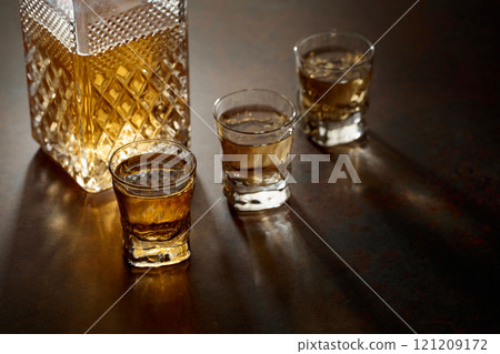 Decanter and small glasses of whiskey. 121209172