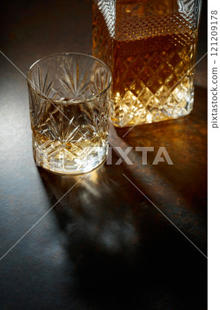 Decanter and cut glass tumbler with whiskey. Decanter and cut glass tumbler with whiskey. 121209178