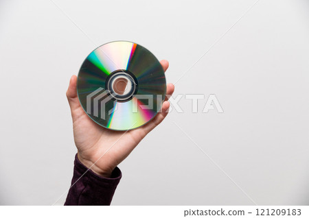 Image of a hand holding a CD, a metaphor for data protection. CD in a woman's hand, old technology Image of a hand holding a CD, a metaphor for data protection. CD in a woman's hand, old technology 121209183