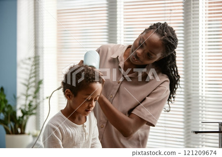 Caring young mother helping little son with drying hair in bathroom during daily hygiene routine, copy space 121209674