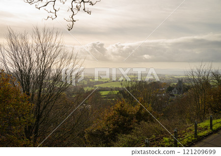 View of the English countryside near Shaftesbury, Dorset with fields, trees, hills and a church. 121209699
