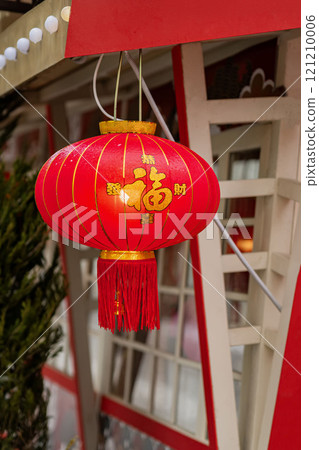 Red lantern hanging outside building, symbol prosperity of festive celebration. Translation: "Wealth" Red lantern hanging outside building, symbol prosperity of festive celebration. Translation: "Wealth" 121210006