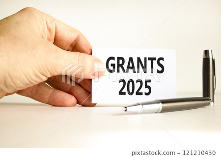 Planning grants 2025 new year symbol. Concept words Grants 2025 on beautiful white card. Beautiful white background. Businessman hand. Business grants 2025 new year concept. Copy space. 121210430
