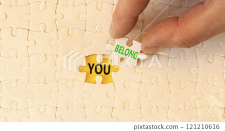 Belonging and you belong symbol. Concept words You belong on beautiful white puzzle. Beautiful white puzzle background. Businessman hand. Business belonging and you belong concept. Copy space. 121210616
