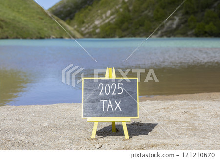 Planning 2025 tax new year symbol. Concept words 2025 Tax on beautiful yellow chalk blackboard. Beautiful mountain lake sand beach background. Business 2025 tax new year concept. Copy space. 121210670