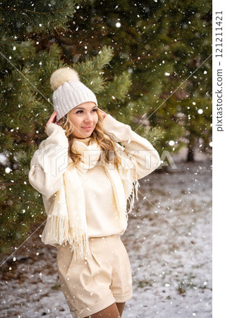 Pretty stylish young woman in forest. Snowy weather. 121211421