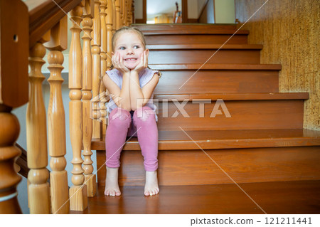 Happy little girl is playing on stairs at home. Dangerous situation at home. Child safety concept.  121211441