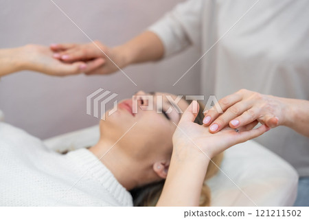 Healer launches body energy through hands before access bars therapy with young woman, stimulating positive change thoughts and emotions. Alternative medicine concept. Healer launches body energy through hands before access bars therapy with young woman, stimulating positive change thoughts and emotions. Alternative medicine concept. 121211502