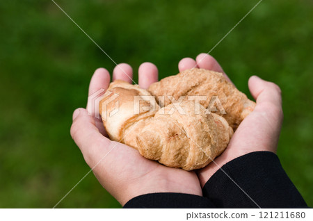 Hands holding fresh pastries outdoors 121211680