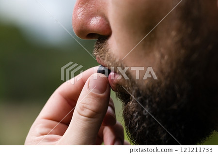 Man eating a berry 121211733