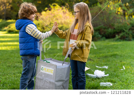 Caucasian kids boy and girl volunteering outdoors cleaning pollution and recycling garbage Caucasian kids boy and girl volunteering outdoors cleaning pollution and recycling garbage 121211828