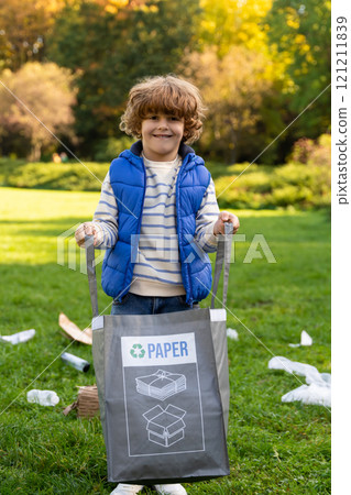 Volunteer little boy collecting paper garbage in park Volunteer little boy collecting paper garbage in park 121211839