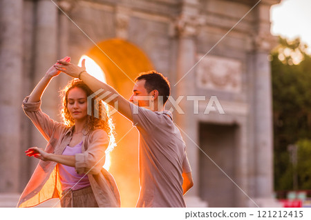 Couple dancing swing in front of puerta de alcala in madrid at sunset 121212415