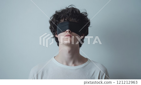 A person stands with their eyes covered by a blindfold, showcasing a tranquil expression while surrounded by a minimalist white background A person stands with their eyes covered by a blindfold, showcasing a tranquil expression while surrounded by a minimalist white background 121212963