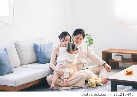 A young family relaxing in the living room　 121213445