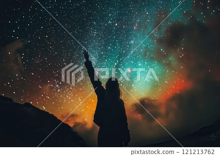 Woman reaching for the stars in colorful night sky 121213762