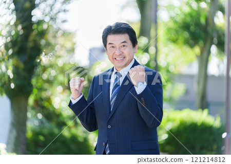 一位 60 多歲的商人正在做握拳動作 121214812