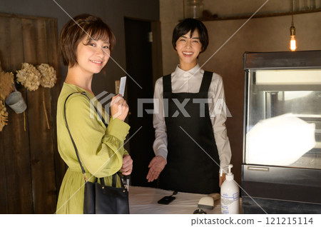 一位女士在商店用卡片付款 一位女士在商店用卡片付款 121215114