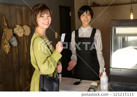 一位女士在商店用卡片付款 一位女士在商店用卡片付款 121215115