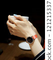 Woman's hand holding a coffee cup in a cafe 121215337