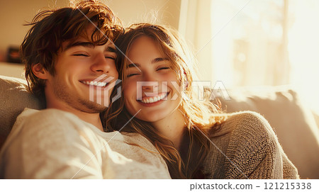 A Caucasian couple sitting on a sofa and embracing each other 121215338
