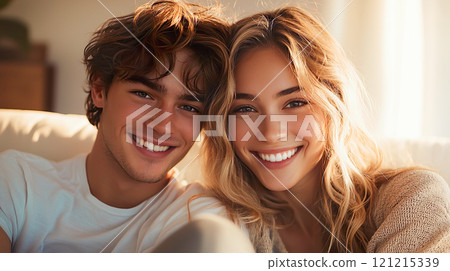 A Caucasian couple sitting on a sofa and embracing each other 121215339
