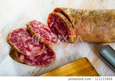 Spanish salchichon sausage cut in slices on a wooden surface Spanish salchichon sausage cut in slices on a wooden surface 121215808