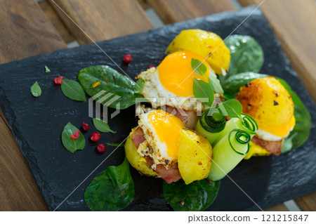 Close up of mini burgers from quail eggs with baked potatoes at plate with greens 121215847
