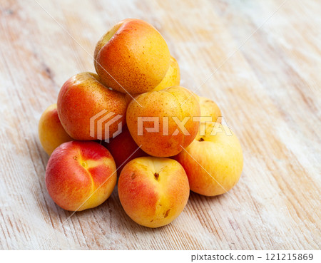 Heap of ripe reddish apricots on wooden table Heap of ripe reddish apricots on wooden table 121215869