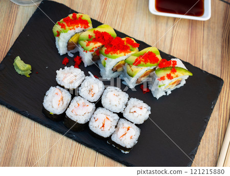 Set of different types of sushi served on board 121215880