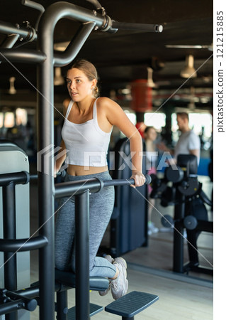 Young woman exercising on gravitron machine Young woman exercising on gravitron machine 121215885