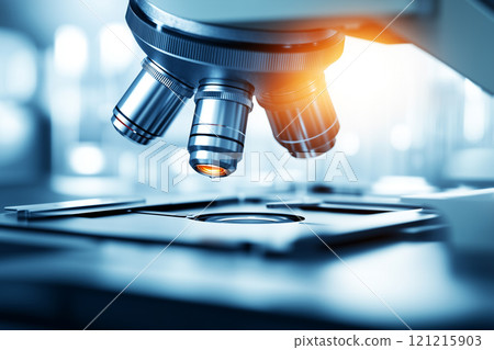 Close-Up of a Precision Microscope with Metal Lens Captured in a Professional Laboratory Setting with Bright Lighting and Advanced Equipment 121215903