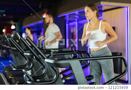 Young woman exercising on treadmill in gym 121215939