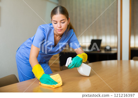 Woman wiping dust from desk 121216397