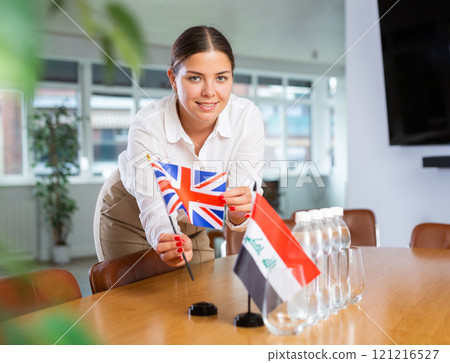 Young lady sets miniatures flags of Iraq and Great Britain for international negotiations 121216527